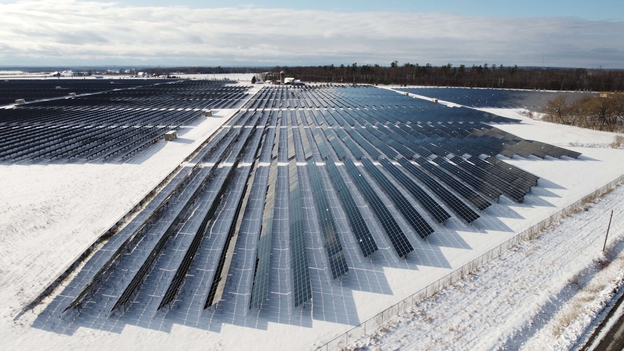 A solar farm covered in snow, showcasing its functionality in cold climates.