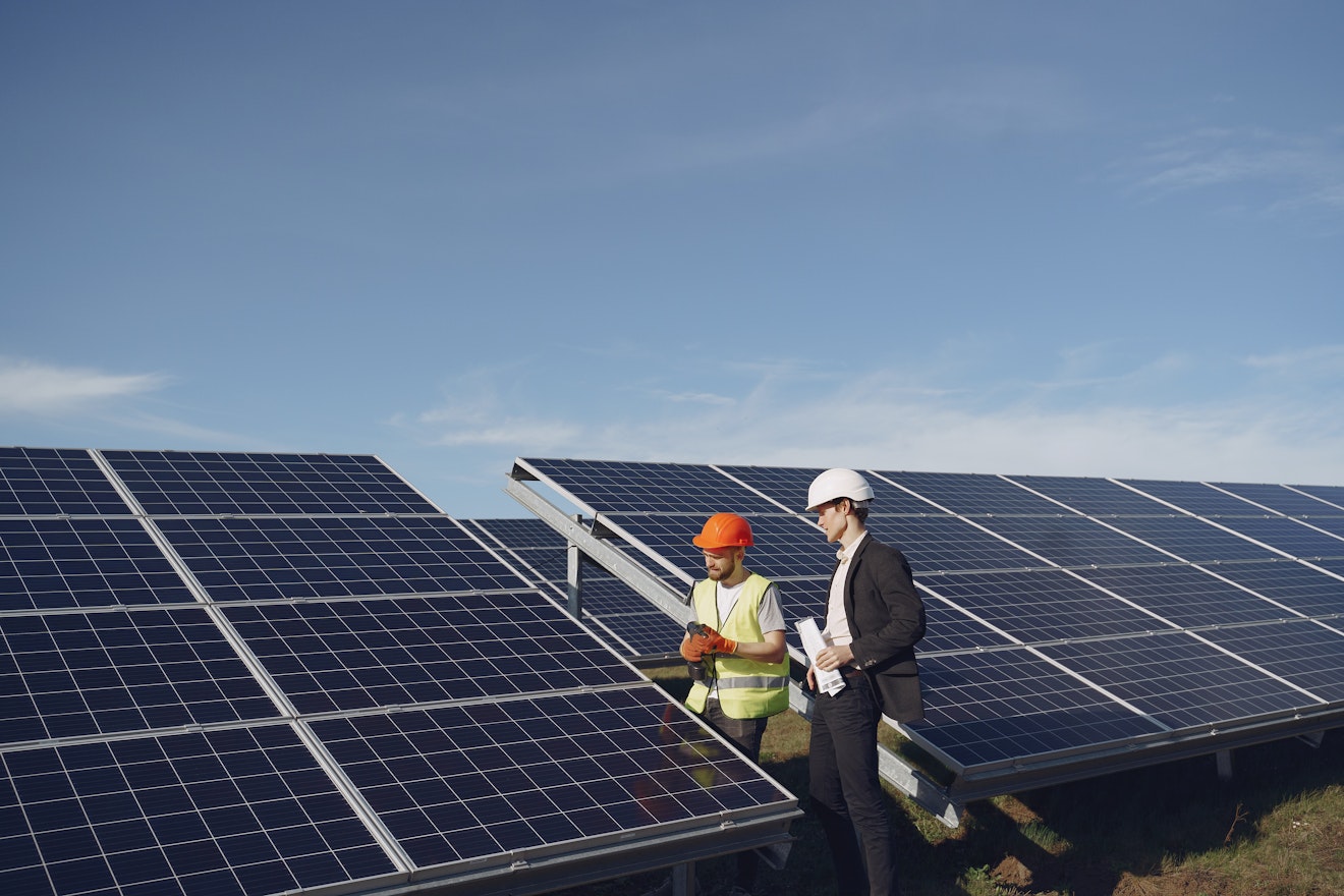 Man in suit and engineer in solar farm