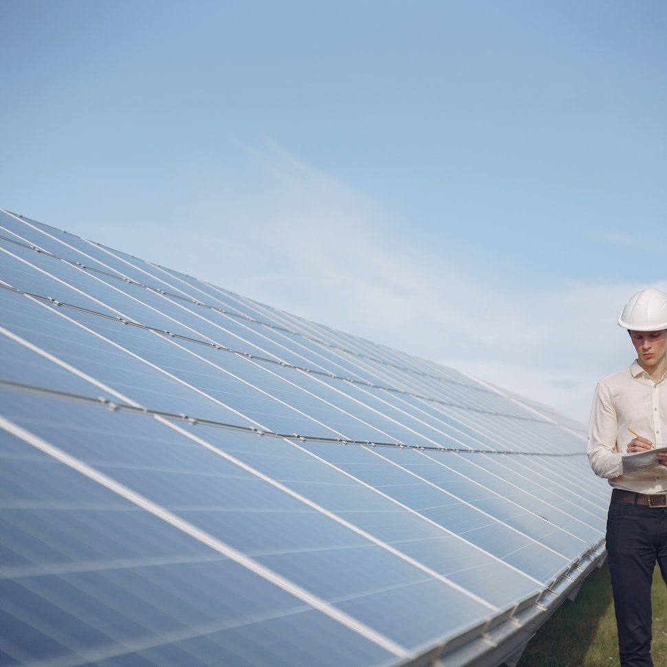 man next to solar panels
